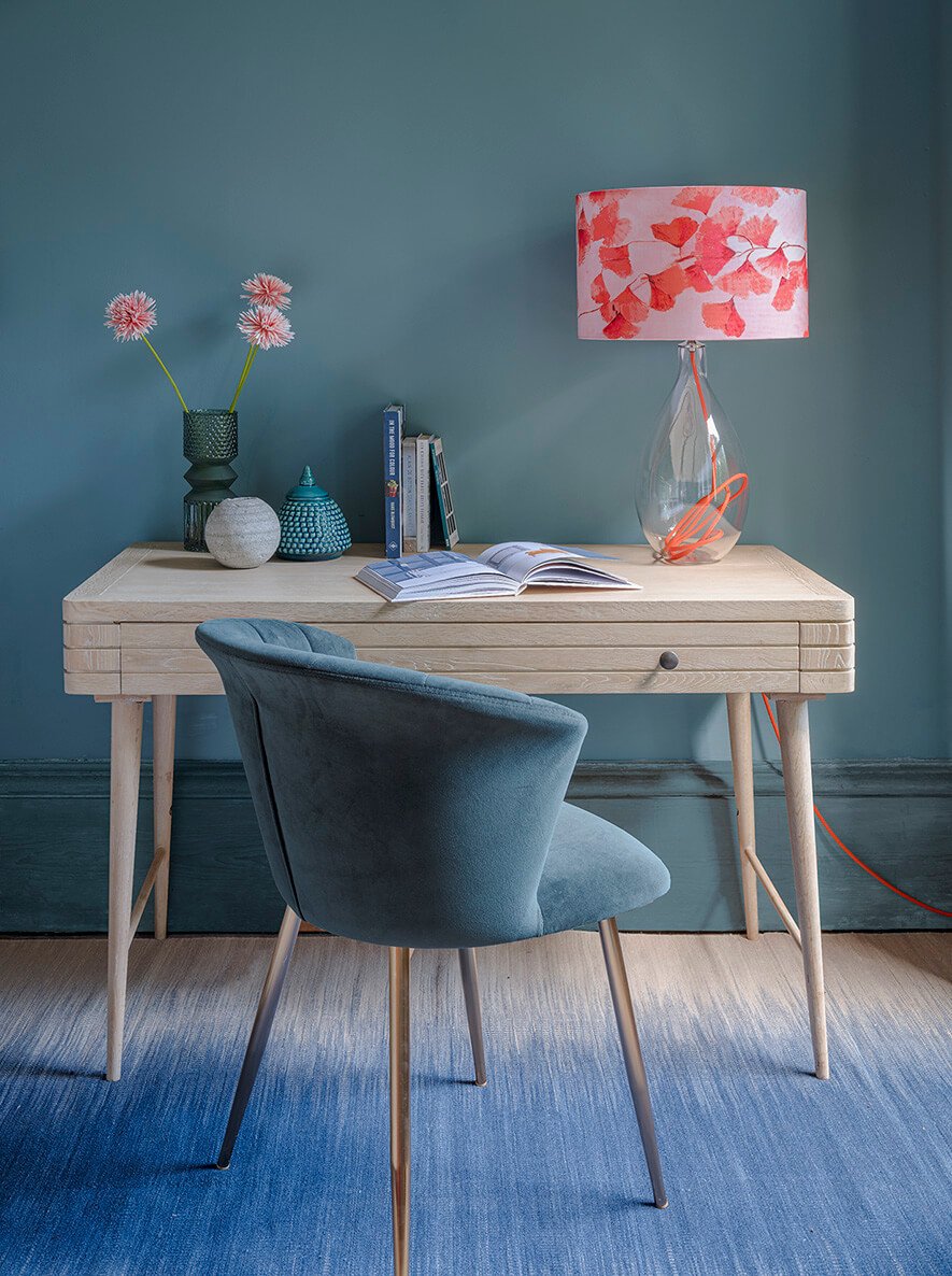 Glass lamp base with clementine orange flex by Anna Jacobs, shown in a home office lifestyle setting with Ginkgo in Coral lampshade