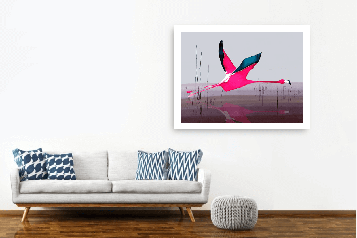 Large pink flamingo print hanging on a white wall beside a grey sofa with blue cushions
